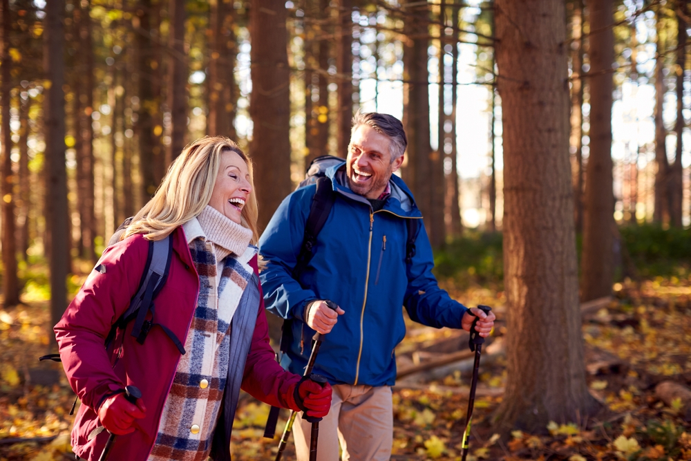 couple hiking in the woods during fall season.