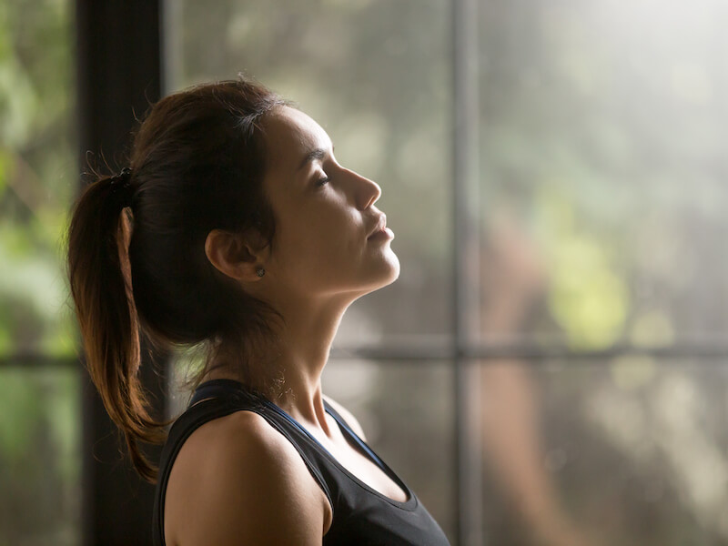 Woman with her eyes closed trying to get relief from tinnitus with retraining therapy.