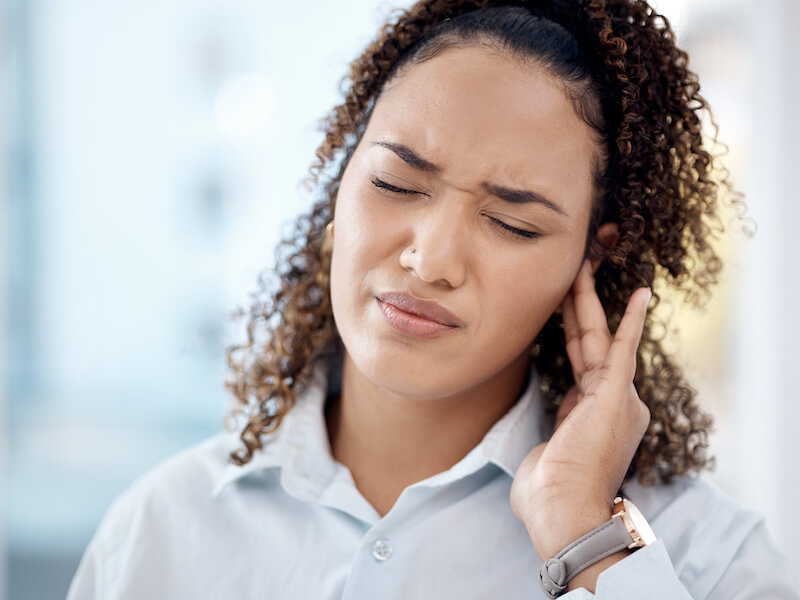 Woman in pain for tinnitus, sound and noise problem. Healthcare, pressure and hearing loss with girl suffering with muffled hearing.